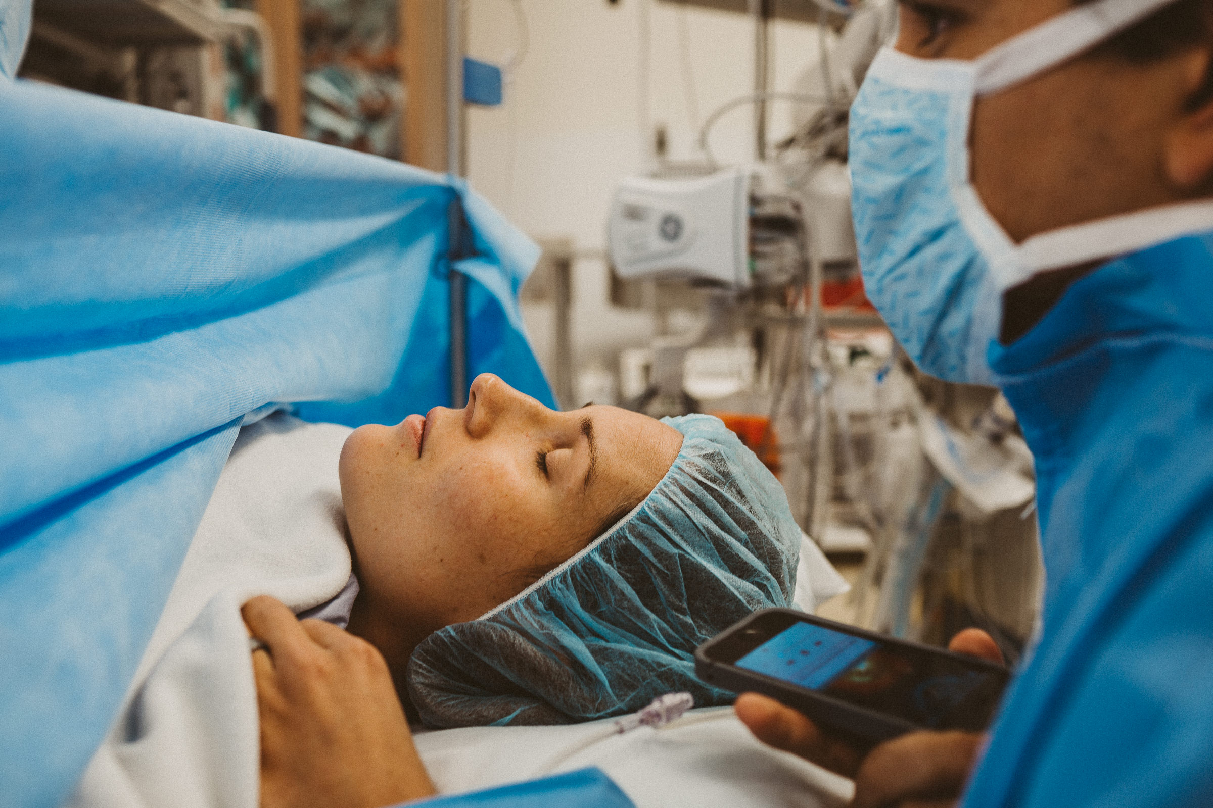 partner comforting mother during cesarean section