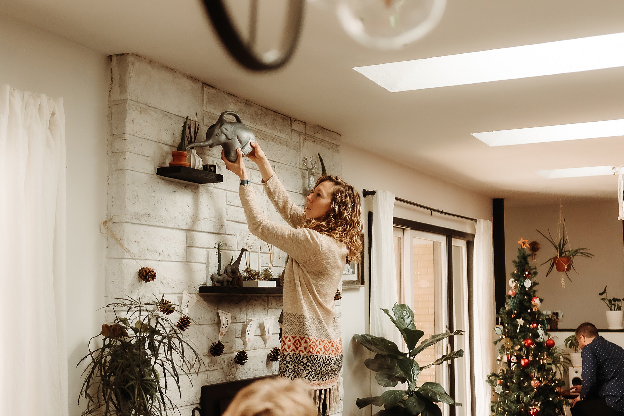 woman watering plants in living room