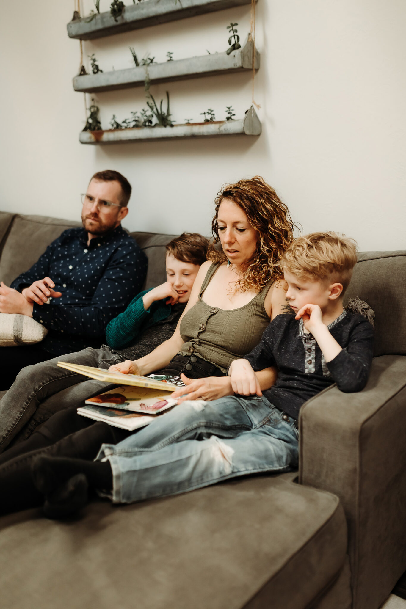 family reading books on couch in denver living room