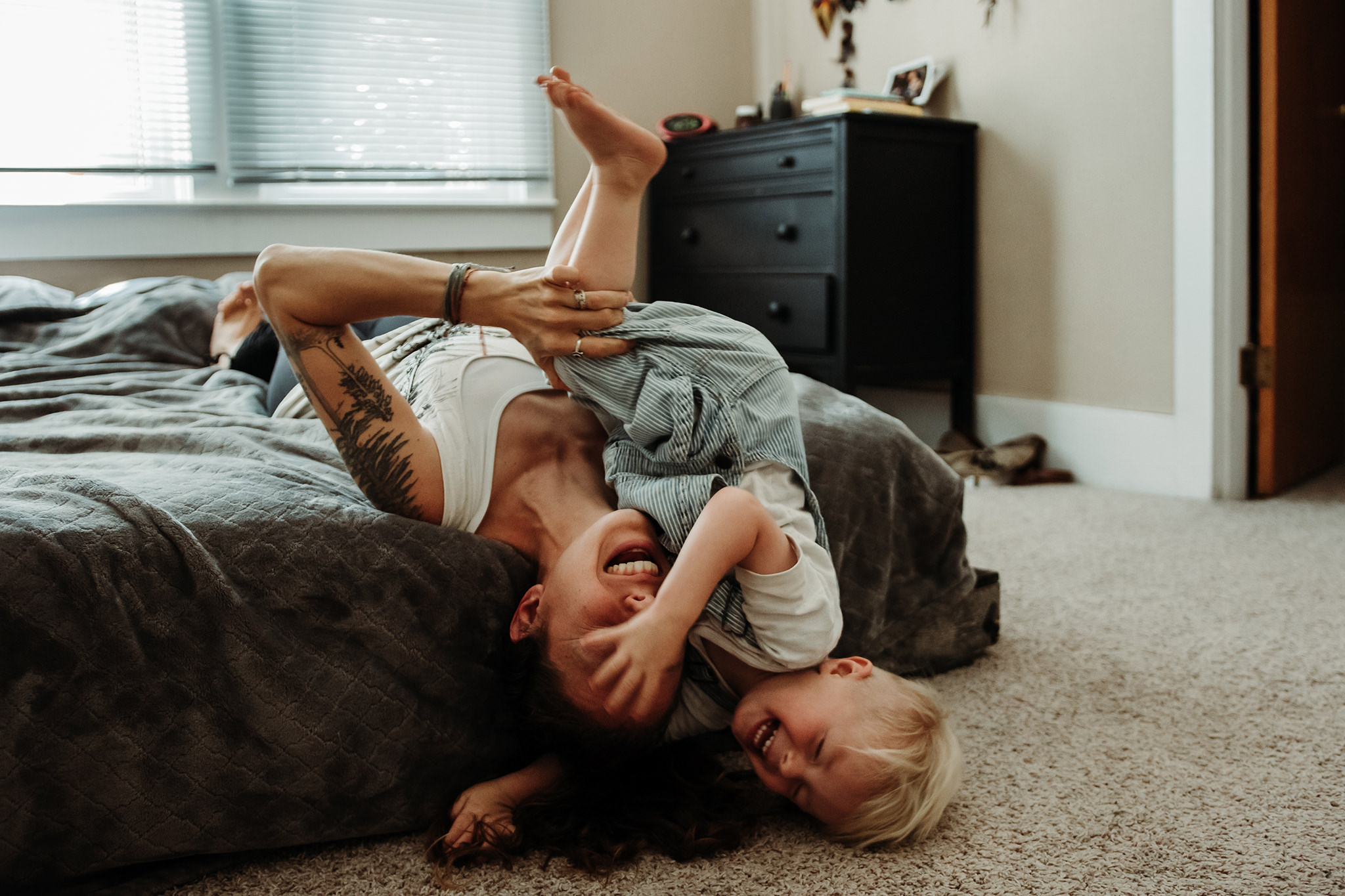 mother and son wrestling in bed and laughing