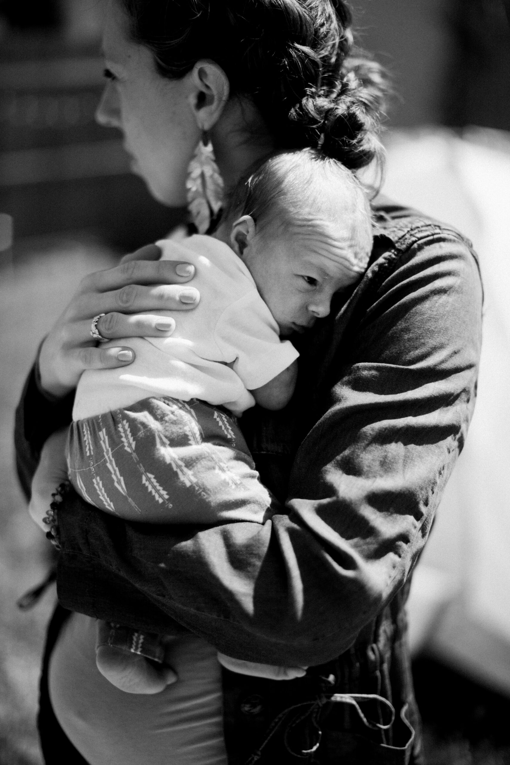 black and white of mother carrying newborn outside