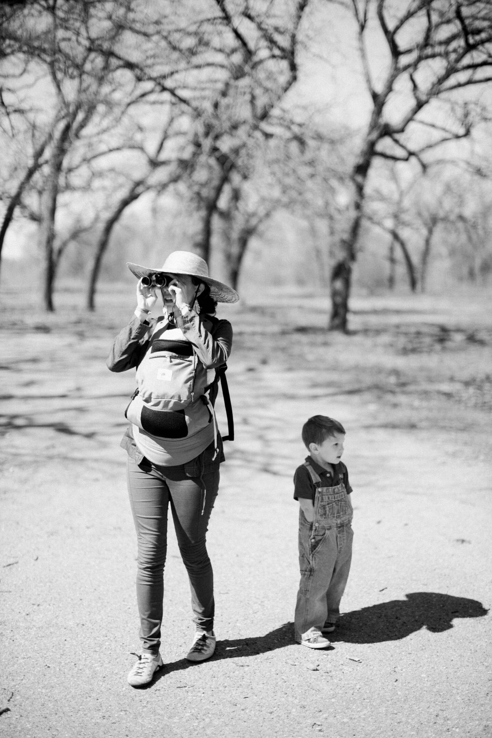 family on an adventure outdoors in colorado, woman with binoculars and baby in a carrier