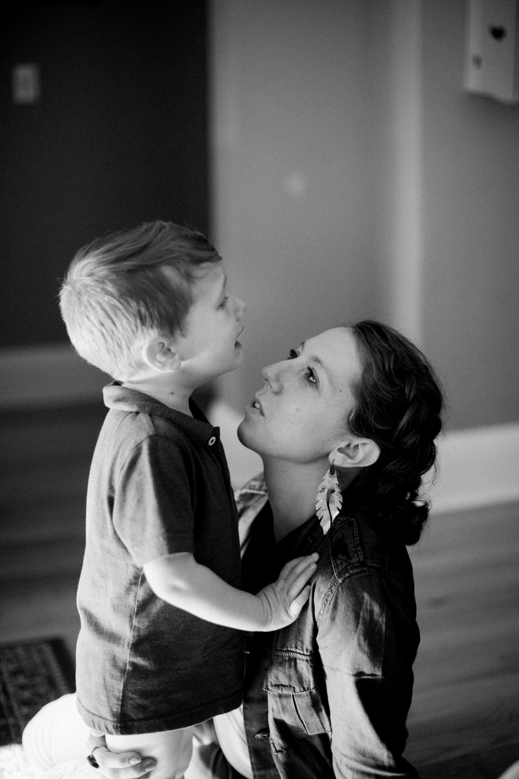 black and white picture of mother comforting crying son in their home