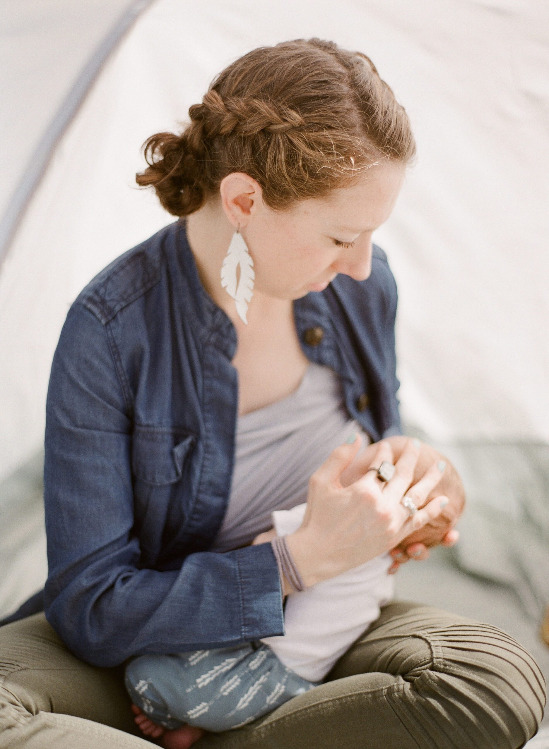 Mom nurses baby in backyard tent