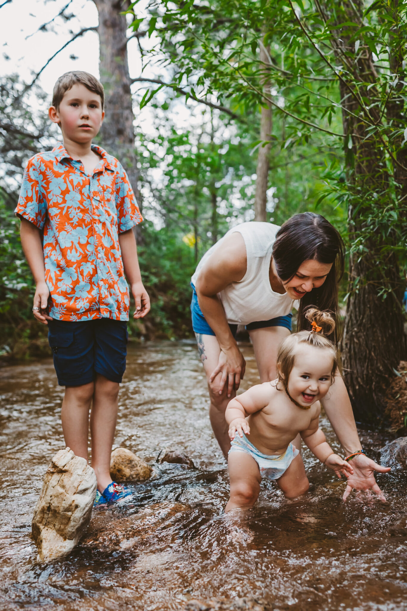 kids and mother playing in the creek