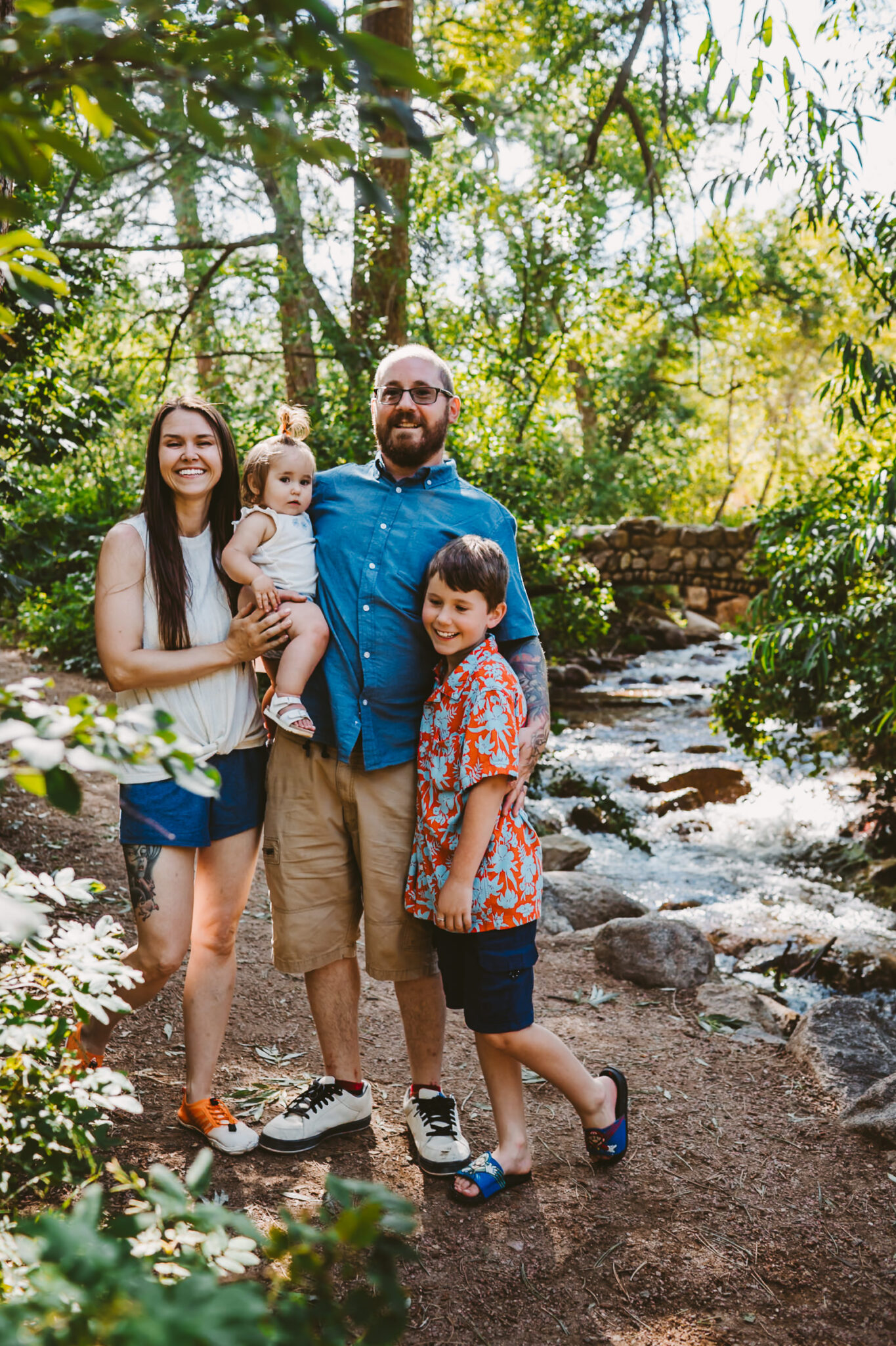 colorado family smiling by a creek in the colorado mountains