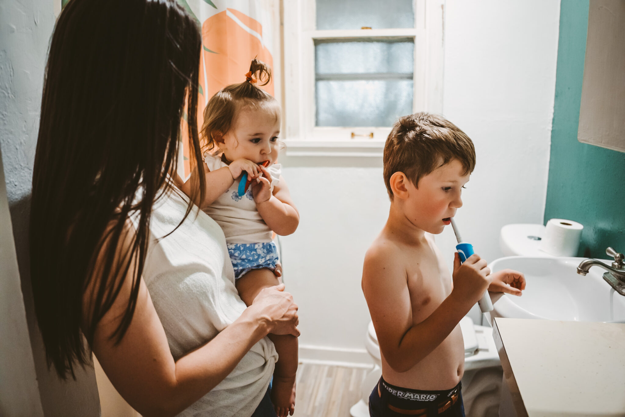 young boy and toddler brush teeth together